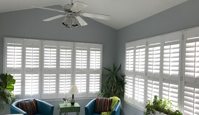 Destin living room with fan and shutters